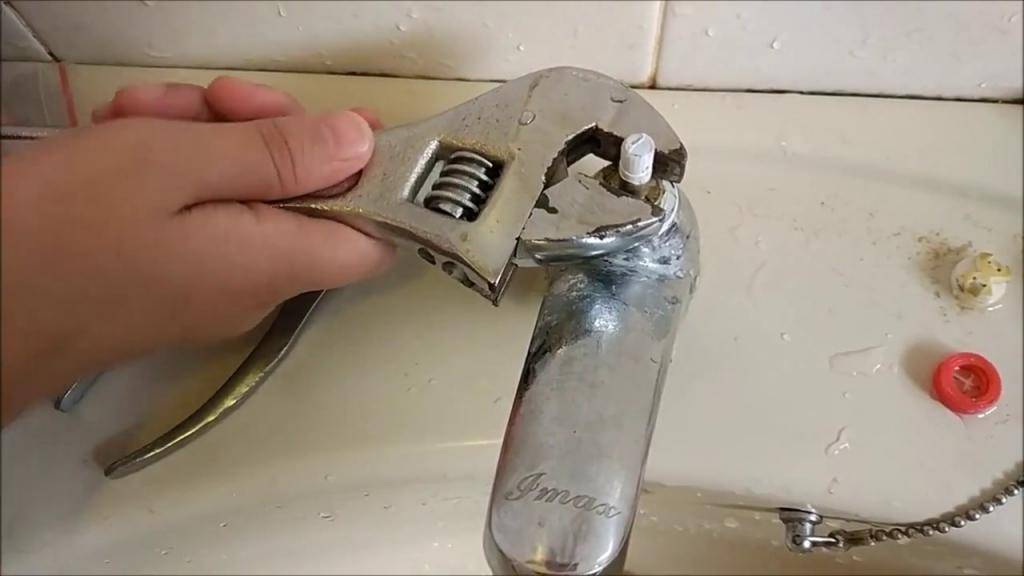Смеситель для ванны ключ нужен. Открутить кран смесителя раковины. Смеситель откручивают. Ключ для откручивания смесителя от раковины. Открутить старый смеситель.